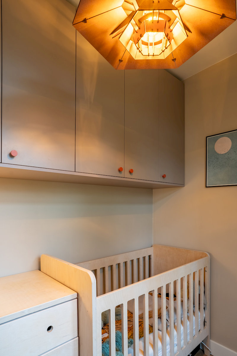 Doorkijk naar wastafelmeubel en kranen in de badkamer