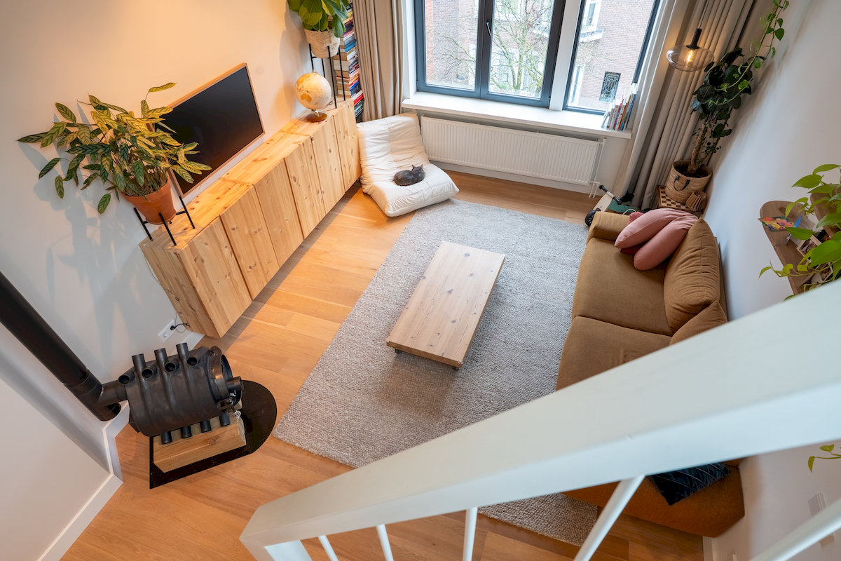 Lichte woonkamer met zicht op de dakopbouw en hoge vide